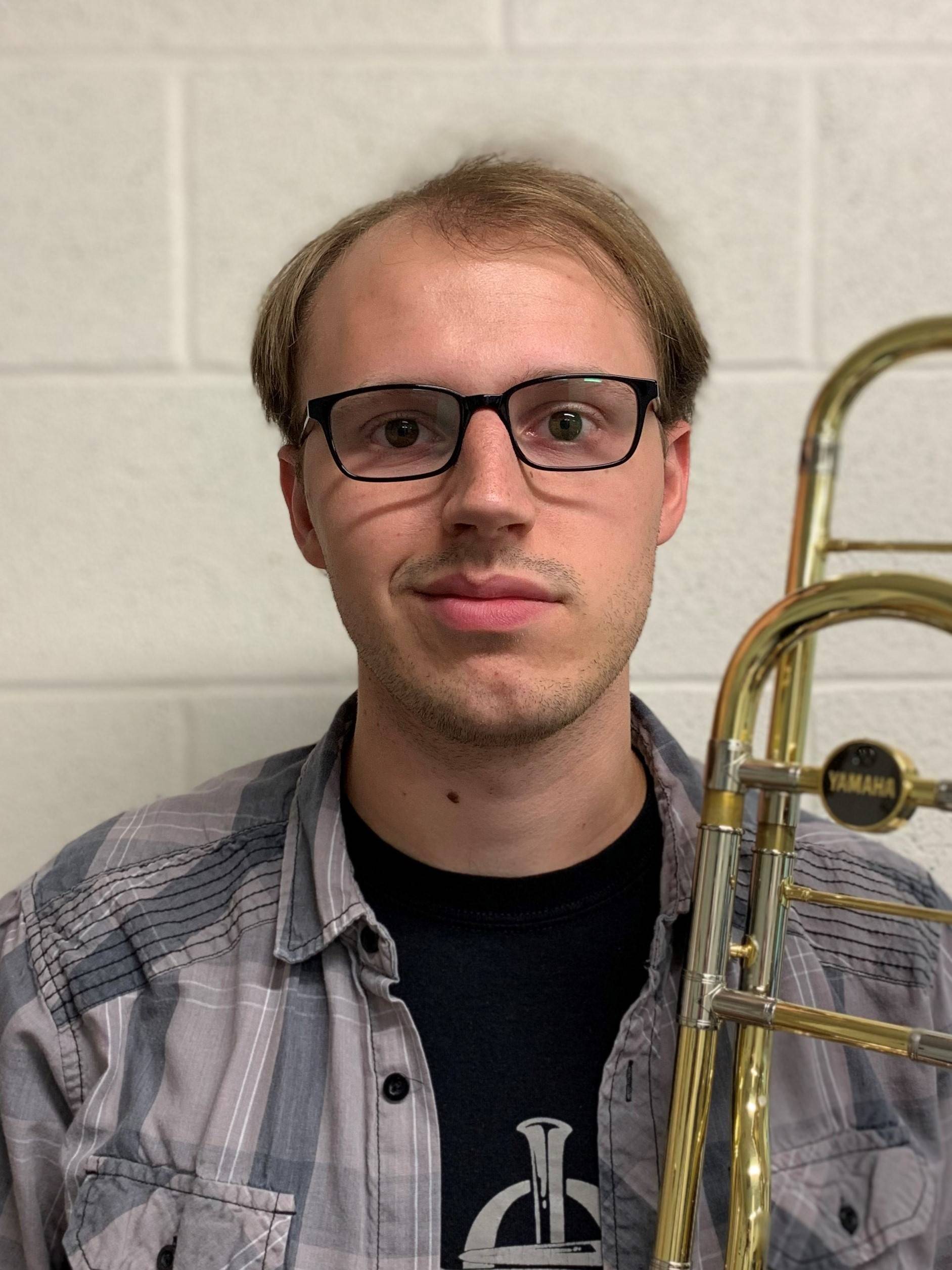 Dylan Schoolcraft holding a tenor trombone